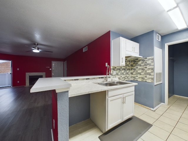 kitchen featuring white cabinets, ceiling fan, sink, and light hardwood / wood-style flooring