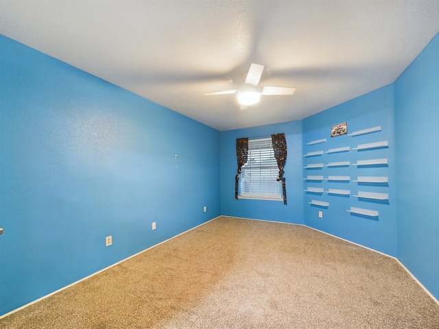 spare room featuring carpet and ceiling fan