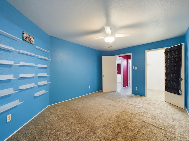 carpeted spare room with ceiling fan and a textured ceiling