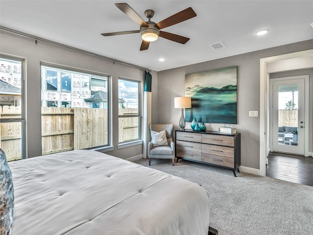 carpeted bedroom featuring access to outside, multiple windows, and ceiling fan