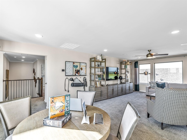 dining area featuring ceiling fan, light colored carpet, and ornamental molding