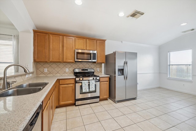 kitchen featuring backsplash, stainless steel appliances, vaulted ceiling, sink, and light tile patterned floors