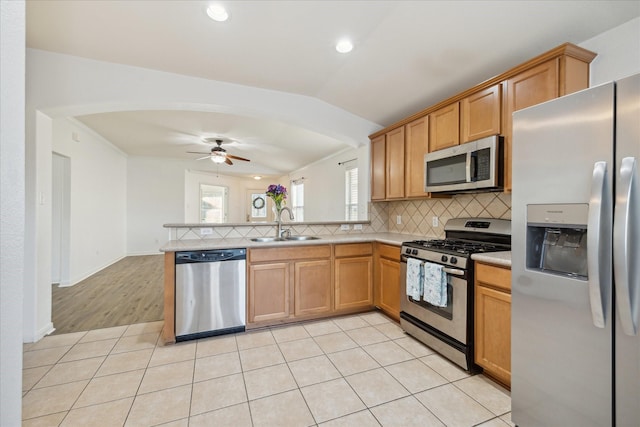 kitchen with sink, ceiling fan, light hardwood / wood-style floors, kitchen peninsula, and stainless steel appliances