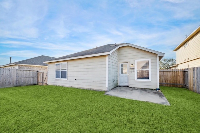 rear view of property featuring a lawn and a patio