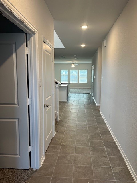 corridor featuring dark tile patterned flooring