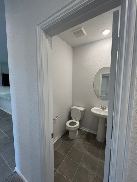 bathroom featuring sink, tile patterned flooring, and toilet