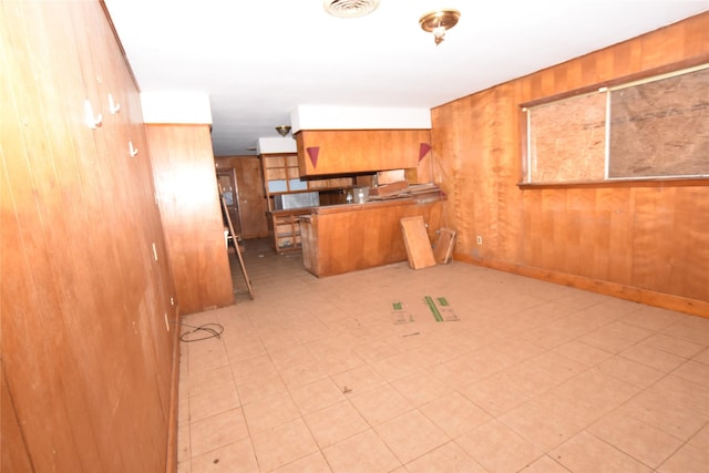 kitchen featuring kitchen peninsula and wood walls