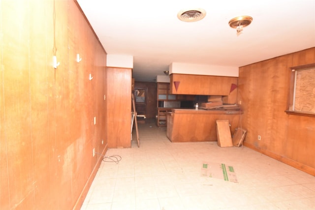 kitchen featuring wood walls and kitchen peninsula