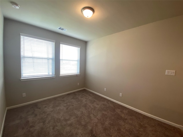 empty room featuring dark colored carpet