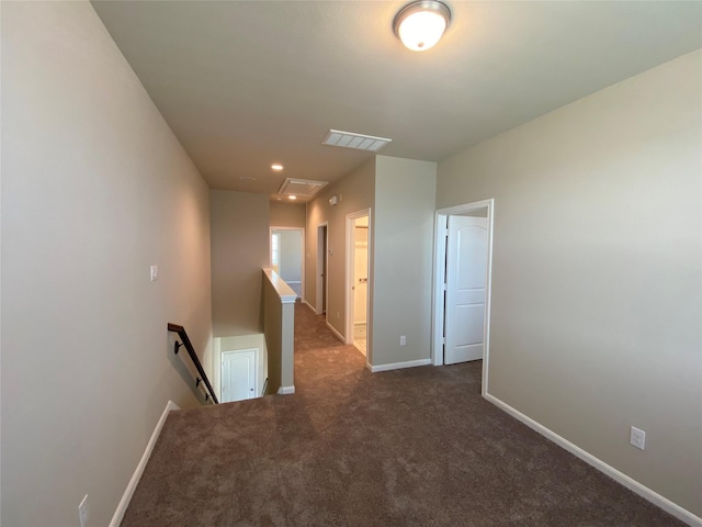 hall with dark colored carpet