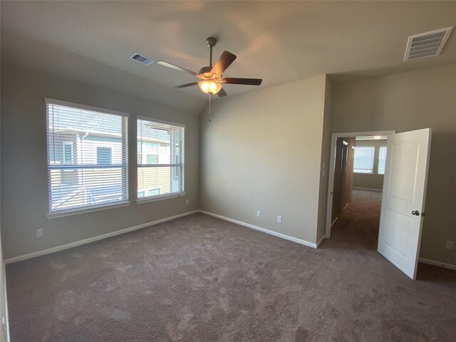 unfurnished room featuring dark colored carpet and ceiling fan