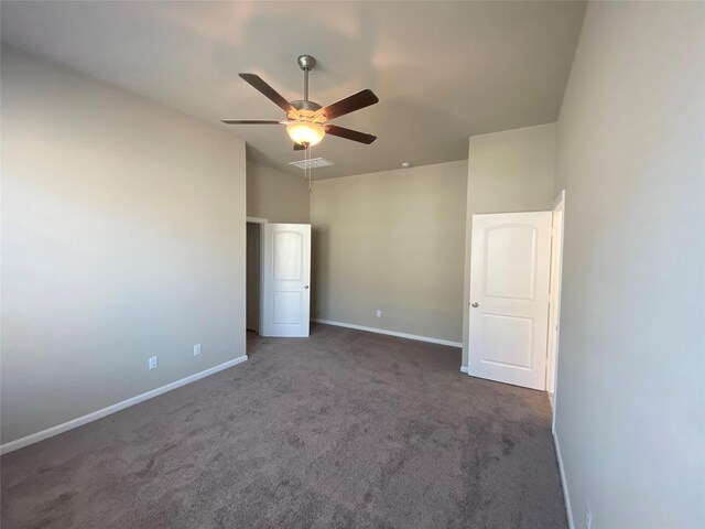 unfurnished bedroom featuring ceiling fan and dark carpet