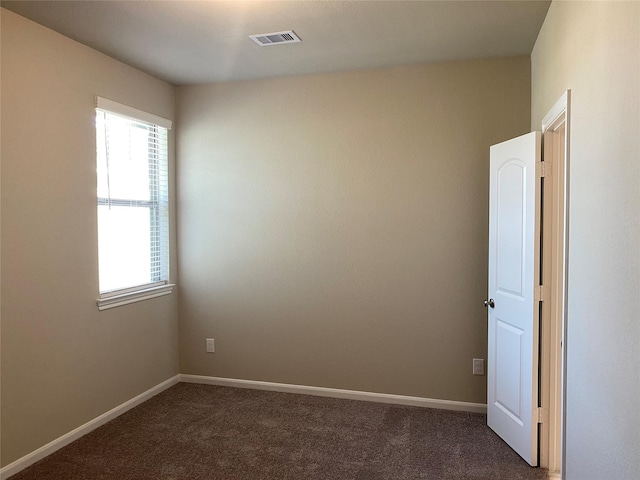 empty room with dark colored carpet