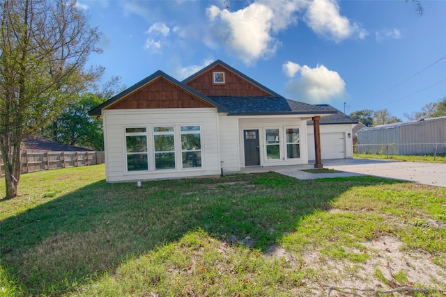 back of property featuring a lawn and a garage