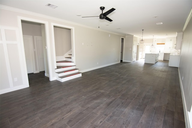 unfurnished living room with ceiling fan, dark wood-type flooring, and ornamental molding