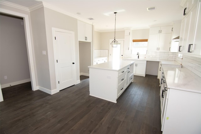 kitchen with dark hardwood / wood-style floors, a kitchen island, white cabinetry, and hanging light fixtures