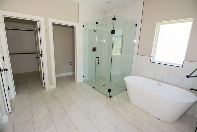 bathroom featuring tile patterned flooring, separate shower and tub, and tile walls