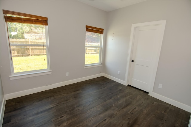 spare room with plenty of natural light and dark hardwood / wood-style floors