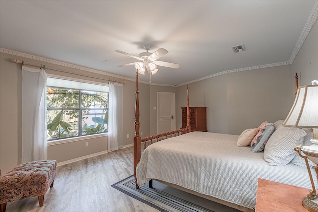 bedroom featuring light wood-type flooring, ceiling fan, and crown molding