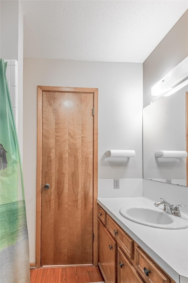 bathroom featuring vanity, wood-type flooring, and a textured ceiling