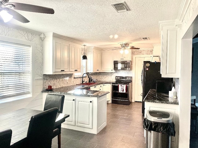 kitchen featuring white cabinets, black range with electric stovetop, hanging light fixtures, and sink