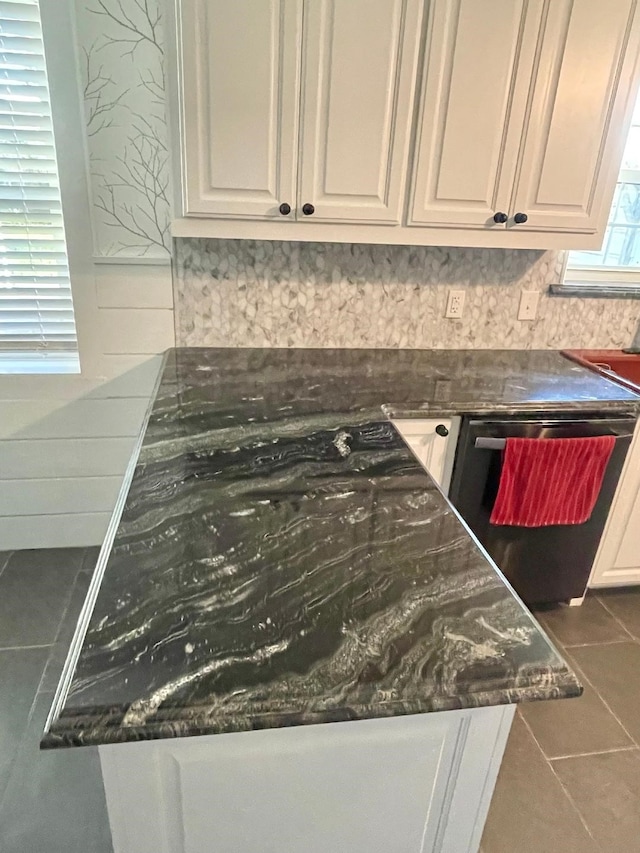 details featuring white cabinets, decorative backsplash, and black dishwasher