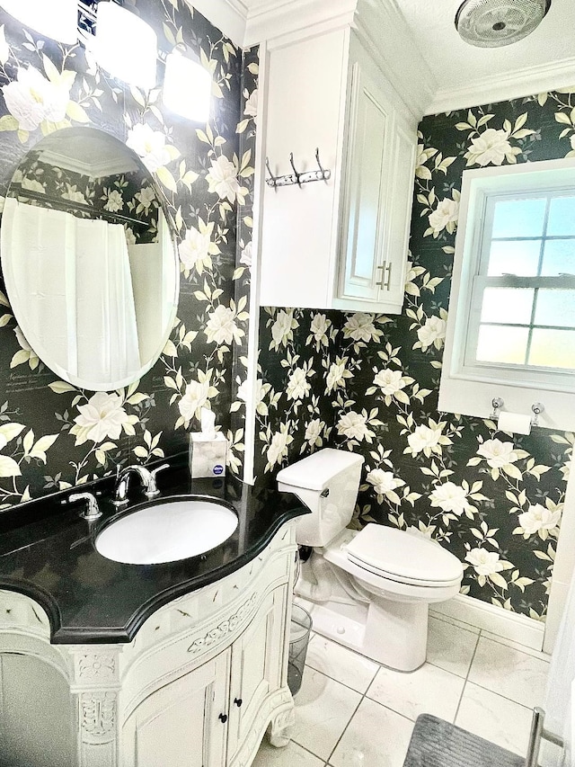 bathroom with tile patterned floors, vanity, toilet, and crown molding