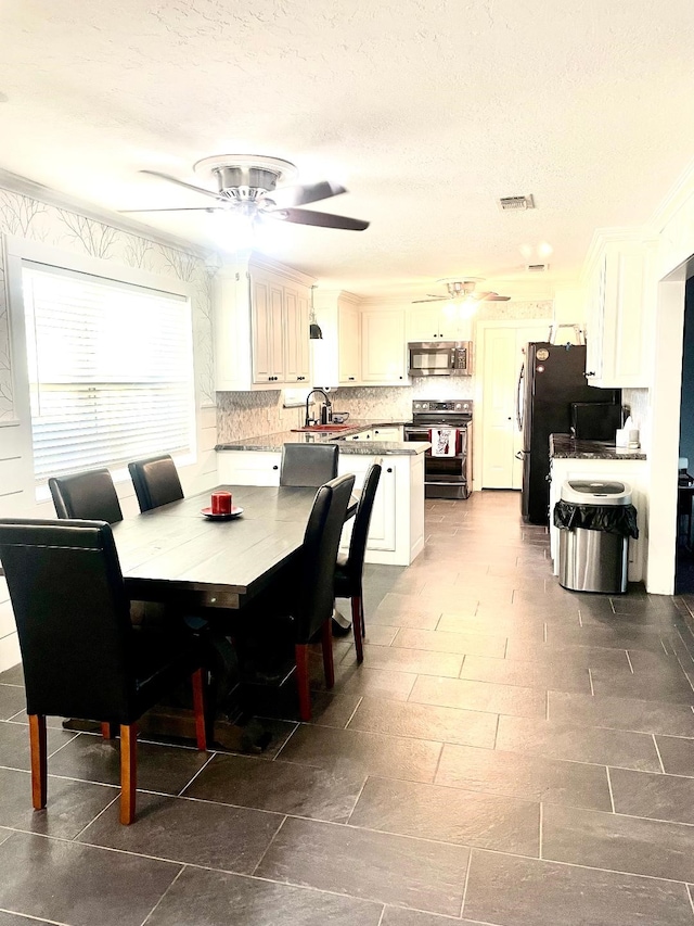 dining area featuring a textured ceiling, ornamental molding, and sink