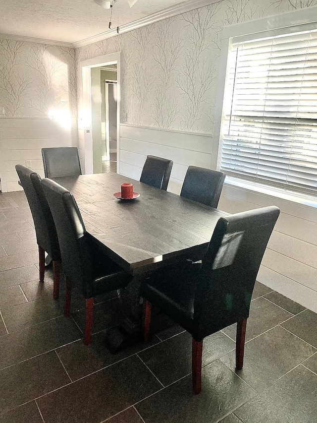 dining space featuring a textured ceiling and ornamental molding