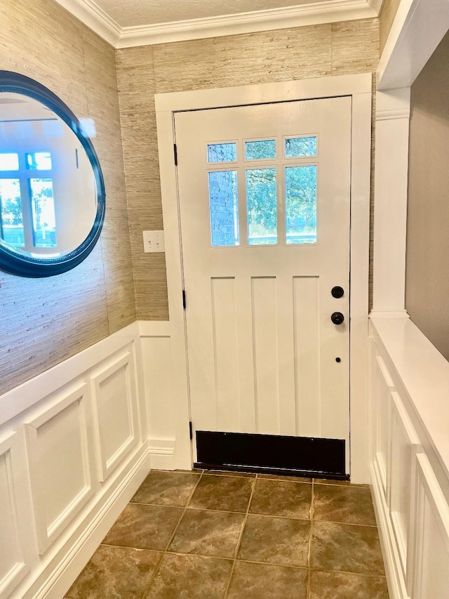 doorway featuring crown molding and dark tile patterned floors