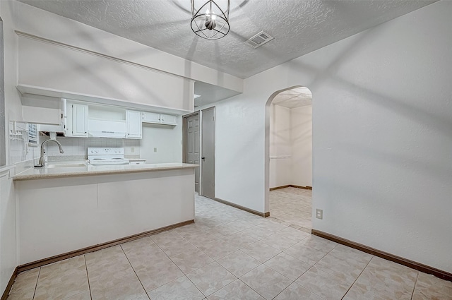 kitchen featuring white cabinets, electric stove, sink, decorative backsplash, and a textured ceiling