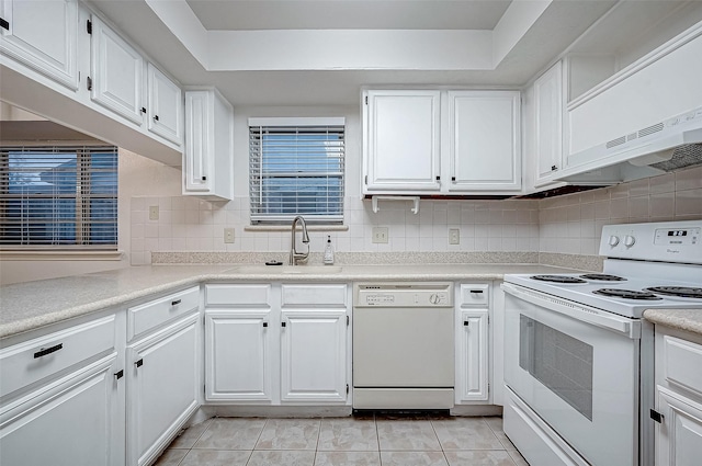 kitchen with white appliances, sink, light tile patterned floors, tasteful backsplash, and white cabinetry