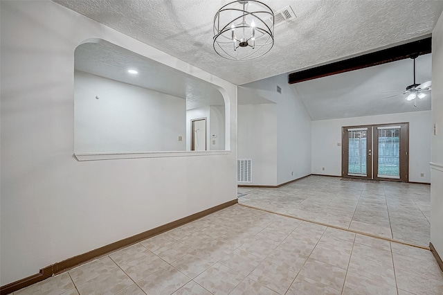 empty room with french doors, ceiling fan with notable chandelier, a textured ceiling, lofted ceiling with beams, and light tile patterned flooring