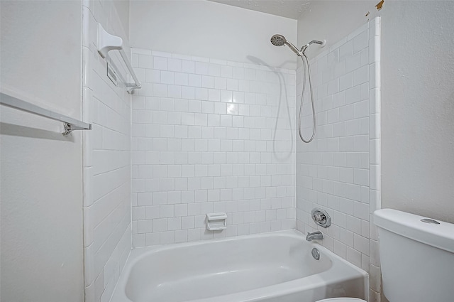 bathroom with tiled shower / bath combo and toilet