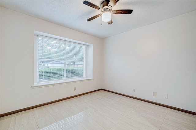 tiled empty room featuring a textured ceiling and ceiling fan