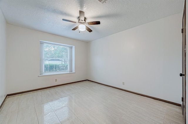 tiled spare room with ceiling fan and a textured ceiling