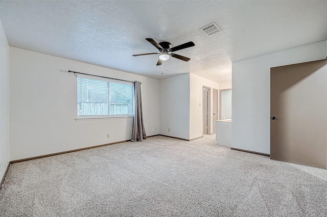 carpeted empty room with ceiling fan and a textured ceiling