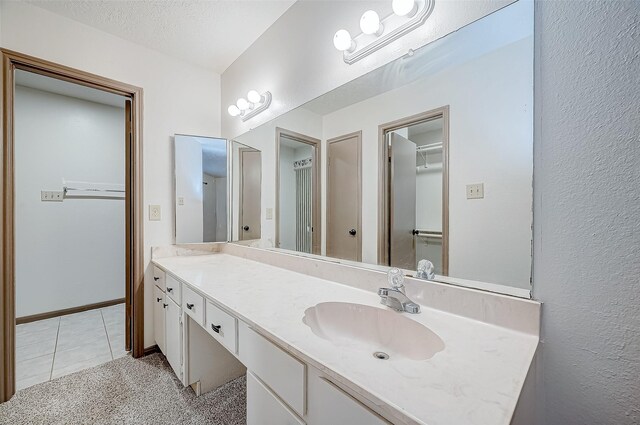 bathroom featuring tile patterned flooring, vanity, and a textured ceiling