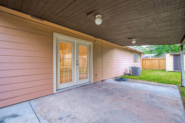 view of patio with cooling unit, a shed, and french doors