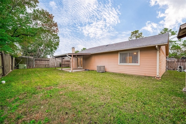 rear view of house featuring a yard, a patio, and central air condition unit