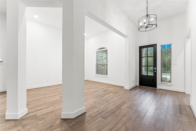 entrance foyer with light hardwood / wood-style floors and a notable chandelier