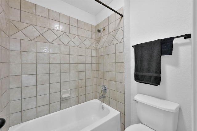 bathroom with tiled shower / bath combo and toilet