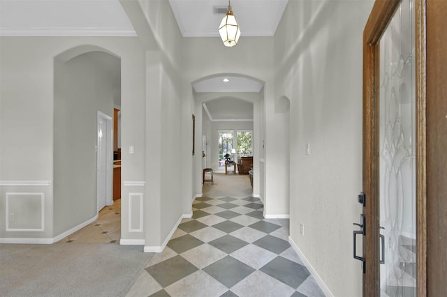 carpeted foyer featuring crown molding