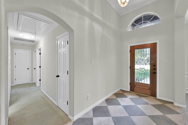 carpeted entrance foyer featuring crown molding