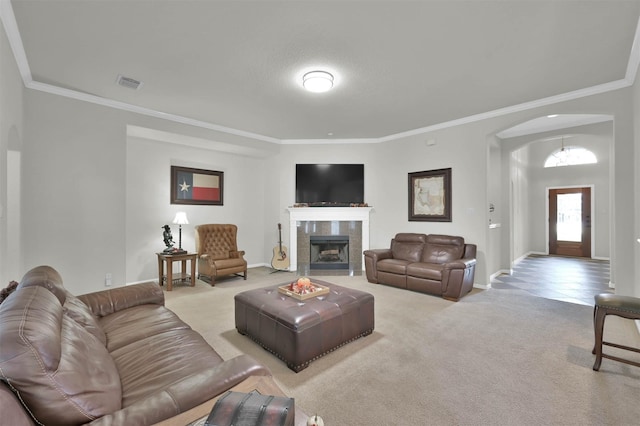 living room featuring carpet, crown molding, and a tiled fireplace