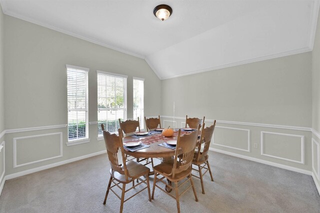 dining room with light carpet, lofted ceiling, and ornamental molding