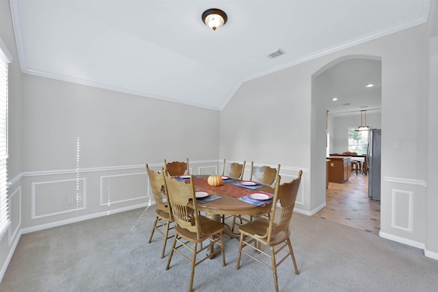 carpeted dining area with crown molding