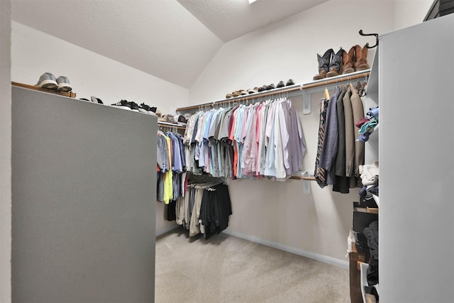 walk in closet featuring light carpet and vaulted ceiling