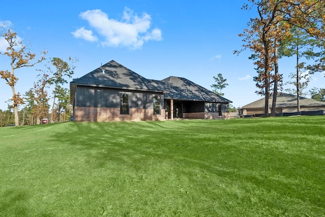 rear view of house featuring a yard