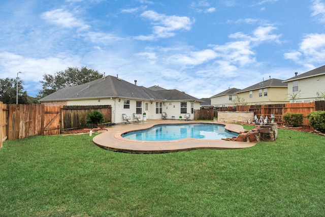 view of pool with a lawn and a patio